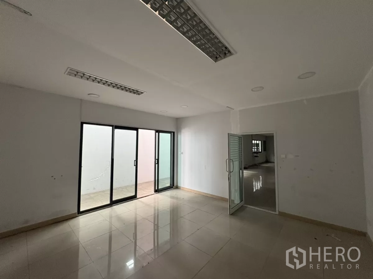 คลังสินค้า ให้เช่าในBang Phli, Samut Prakan - พื้นที่สำนักงานสว่าง พื้นกระเบื้อง ฝ้าเพดานติดโคมไฟ และกระจกบานเลื่อนขนาดใหญ่.