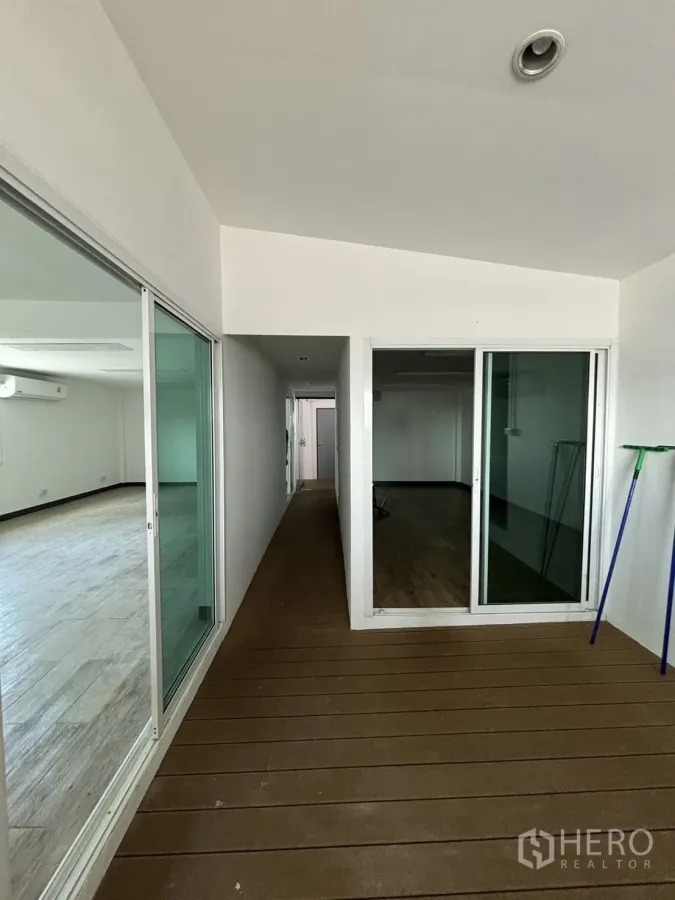Office Space for rent in Watthana, Bangkok - Glass-partitioned corridor leading to private offices with wood flooring.