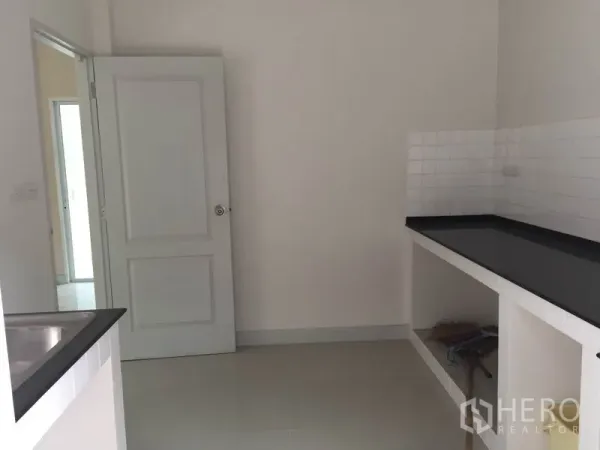 Detached House for rent in Saphan Sung, Bangkok - Separate kitchen with black countertops, white tile backsplash and a stainless-steel sink.