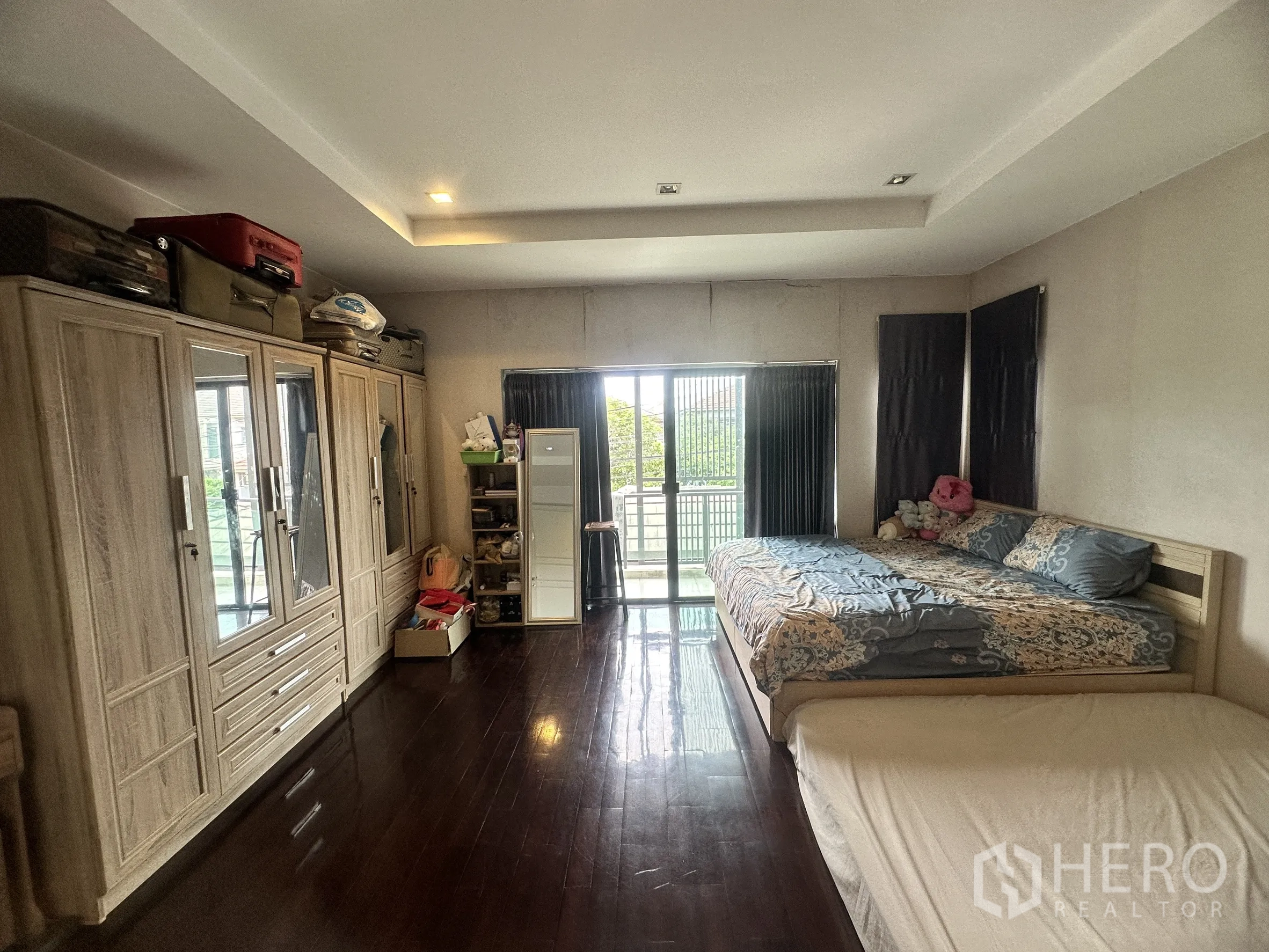 Detached House for sale in Pak Kret, Nonthaburi - Spacious bedroom with wardrobes and sliding doors to balcony.