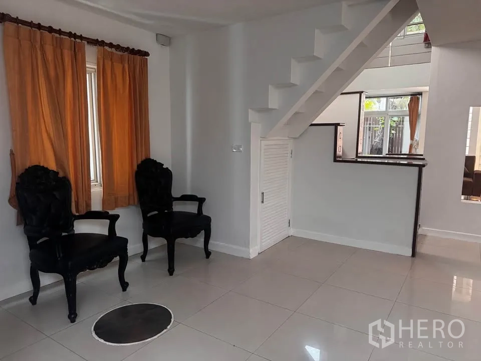 ทาวน์เฮาส์ for rent in Huai Khwang, Bangkok - มุมพื้นที่ใต้บันไดมีเก้าอี้สองตัวและหน้าต่าง.