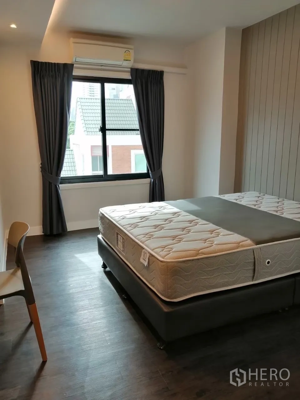 อพาร์ทเมนท์ ให้เช่าในKhlong Toei, Bangkok - ห้องนอนสว่างพร้อมหน้าต่างใหญ่ เครื่องปรับอากาศ และเตียงคู่ พื้นสีเข้ม