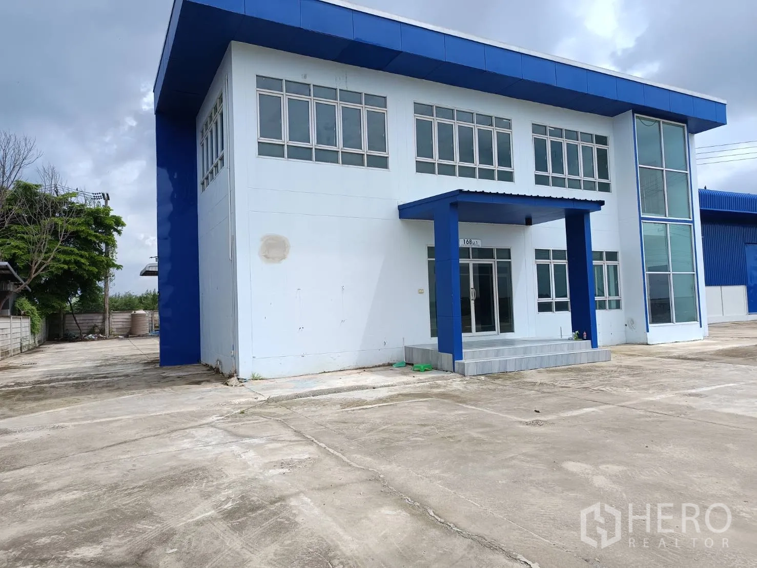 Warehouse for rent in Bang Len, Nakhon Pathom - Two-storey office facade with canopy entrance and many windows.