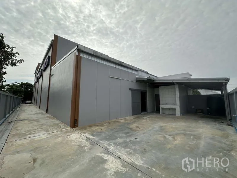 工厂 出租或出售在Bang Bua Thong, Nonthaburi - 建筑后方服务庭院，带雨棚与侧向车道。