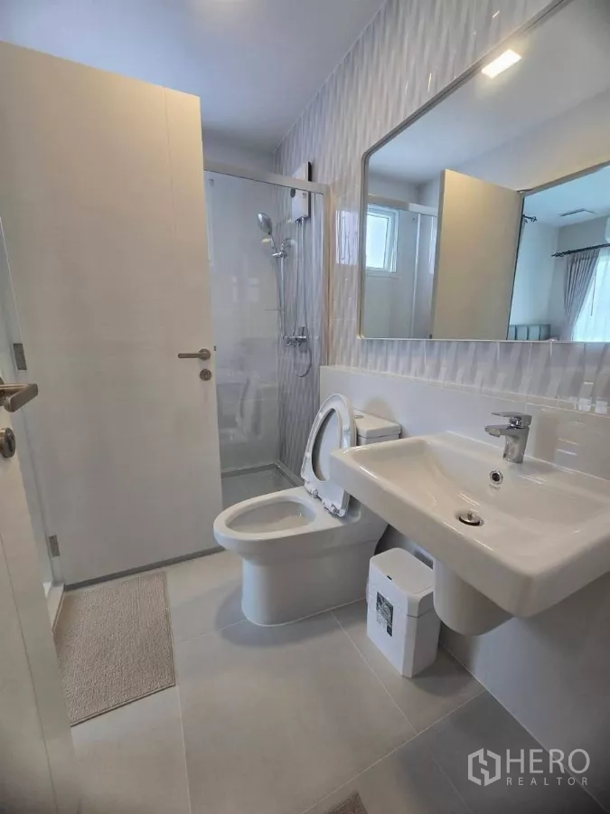 Detached House for rent in Bang Phli, Samut Prakan - Bright bathroom with vanity sink, toilet and glass-enclosed shower.