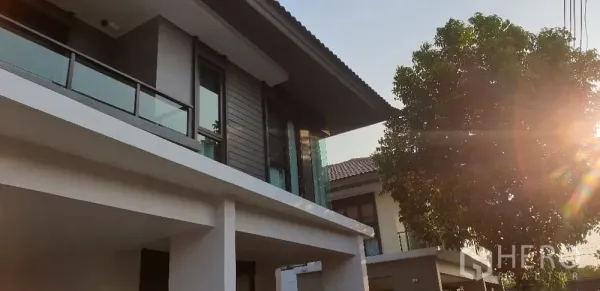 บ้าน ให้เช่าหรือขายในLam Luk Ka, Pathum Thani - ซูมใกล้ด้านหน้าชั้นบน ราวระเบียงกระจกกับแสงอาทิตย์ยามบ่าย