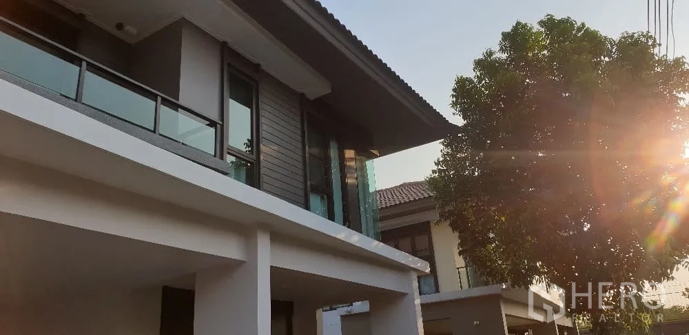 บ้าน ให้เช่าหรือขายในLam Luk Ka, Pathum Thani - ซูมใกล้ด้านหน้าชั้นบน ราวระเบียงกระจกกับแสงอาทิตย์ยามบ่าย