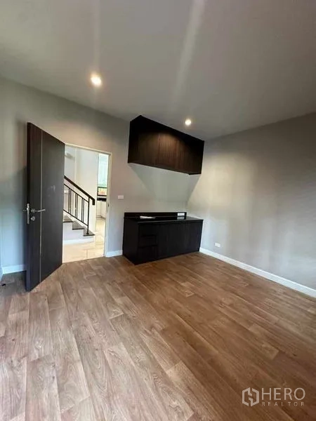 Detached House for sale in Prawet, Bangkok - Spacious bedroom or study with wood floors and a built-in corner cabinet.