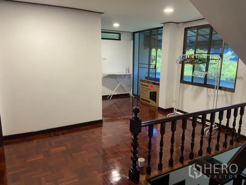 ทาวน์เฮาส์ ให้เช่าในKhlong Toei, Bangkok - โถงชั้นบน พื้นปาร์เกต์ ราวบันไดไม้ หน้าต่างใหญ่ และพื้นที่เชื่อมต่อระเบียง