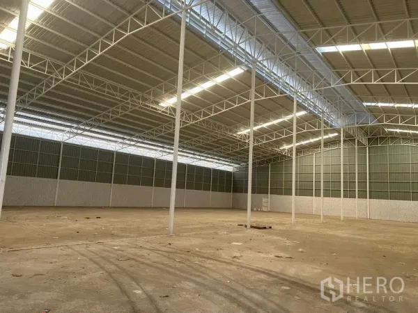 Warehouse for rent in Lat Krabang, Bangkok - Expansive Lat Krabang warehouse interior with high steel-truss roof, skylights, and concrete floor.