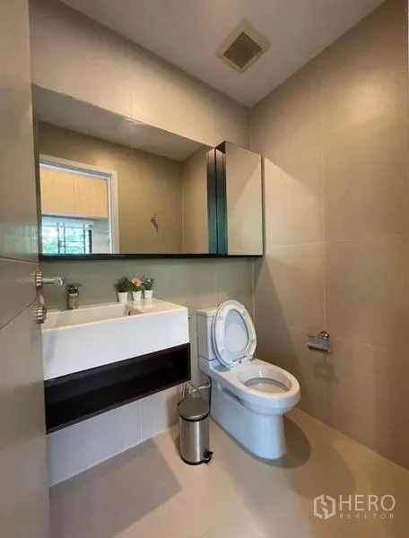 Townhouse for rent in Yan Nawa, Bangkok - Ground-floor powder room with sink, mirror, and toilet.