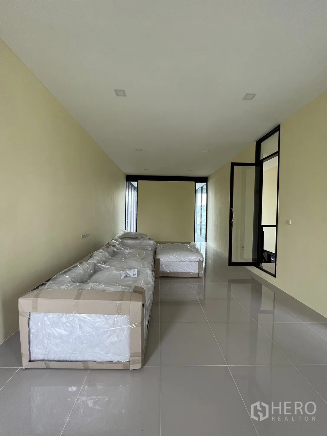 บ้าน ให้เช่าหรือขายในPhra Khanong, Bangkok - ห้องอเนกประสงค์ชั้นบนยาว มีเฟอร์นิเจอร์ห่อพลาสติกบนพื้นมันวาว