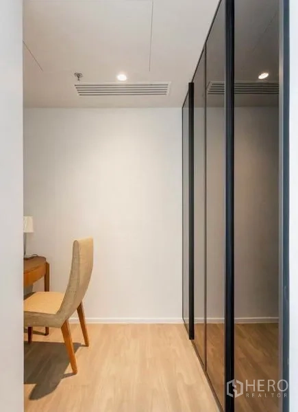 公寓 出租在Bang Rak, Bangkok - 更衣走廊，内置镜面衣柜与梳妆书桌。