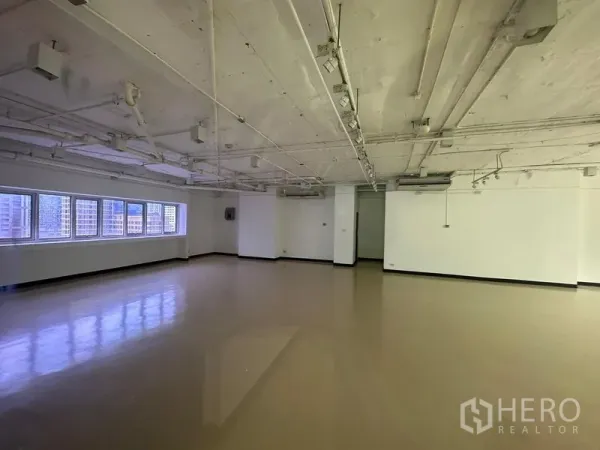 办公空间 出租在Pathum Wan, Bangkok - 宽敞转角办公室，白墙、多扇窗户与吊装空调，步行可到BTS奇隆站。