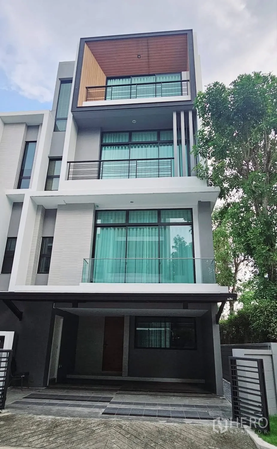Townhouse for rent in Saphan Sung, Bangkok - Contemporary multi-storey townhouse exterior with balconies and covered carport.