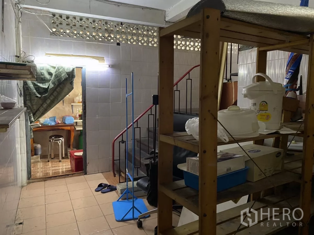 店屋 出租在Khlong Toei, Bangkok - 杂物区带木质置物架与楼梯，墙面为瓷砖。