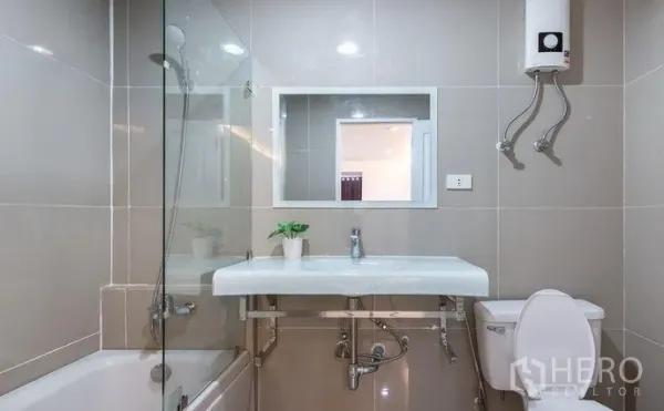 คอนโด ให้เช่าในKhlong Toei, Bangkok - ห้องน้ำสมัยใหม่พร้อมอ่างอาบน้ำ ฉากกั้นกระจก อ่างล้างหน้า และเครื่องทำน้ำอุ่นติดผนัง