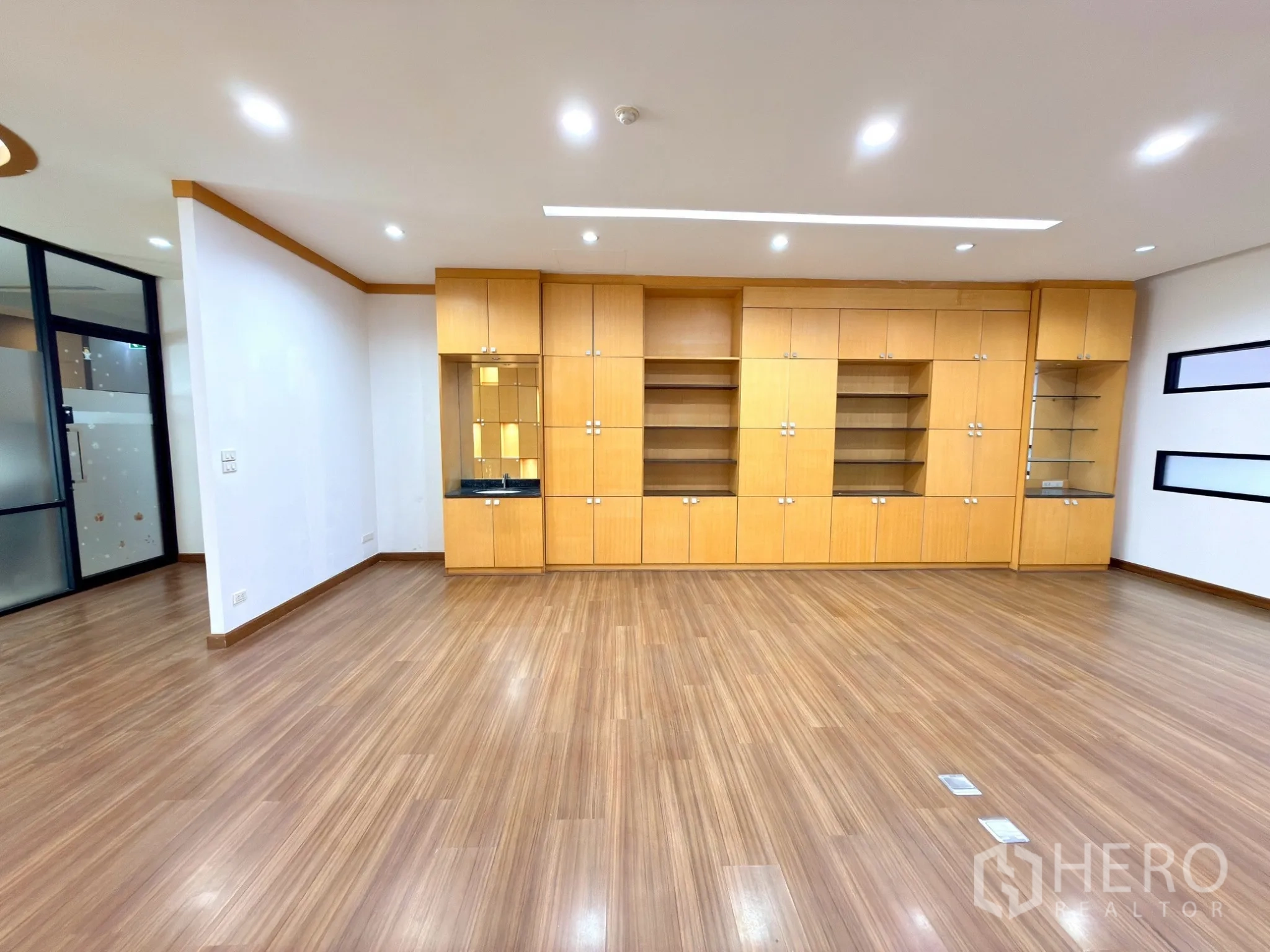 Office Space for rent in Watthana, Bangkok - Corner view highlighting storage cabinets and glass shelving in the meeting area.