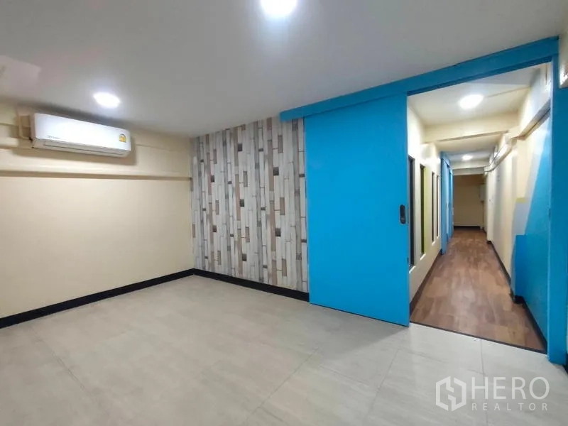 店屋 出租或出售在Bang Rak, Bangkok - 空调房，蓝色推拉门与特色墙，可见走廊景。