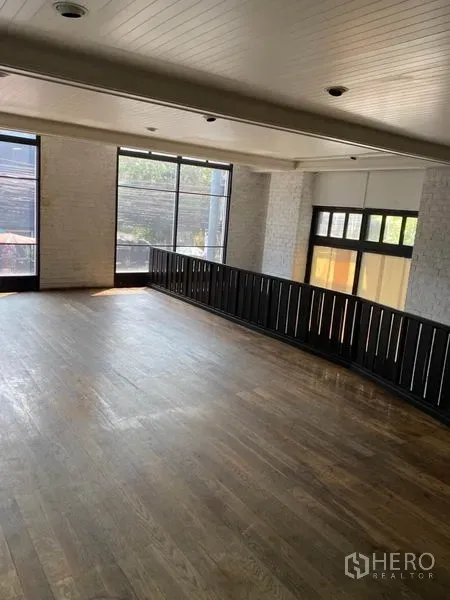 พื้นที่ขายปลีก ให้เช่าในKhlong Toei, Bangkok - ชั้นลอยโปร่งสว่าง พื้นไม้ กระจกบานใหญ่ พร้อมราวกันตกสีดำ