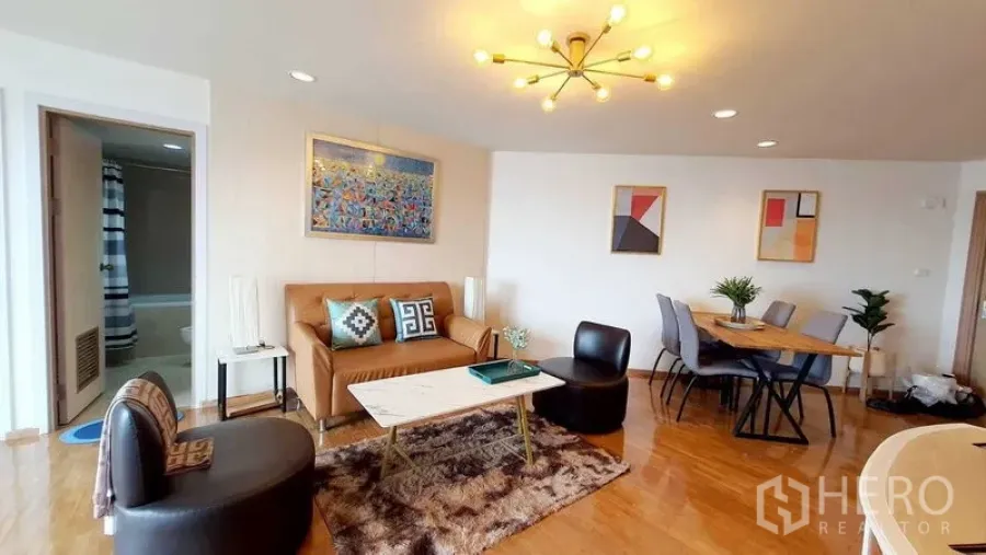 Condominium for sale in Bang Kho Laem, Bangkok - Living room facing dining corner with chandelier lighting and modern decor.