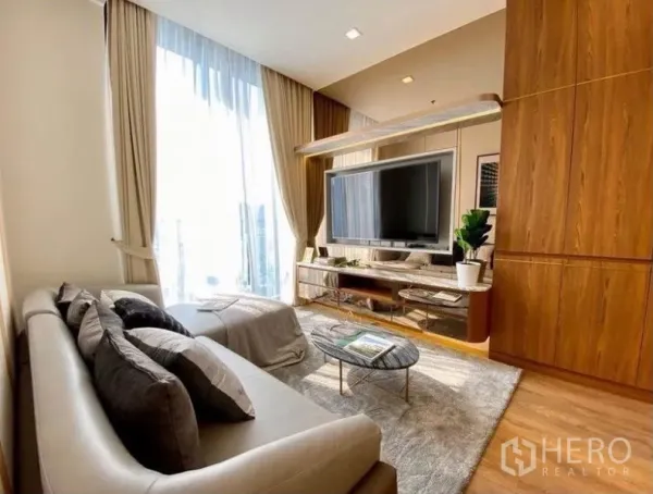 คอนโด ให้เช่าในWatthana, Bangkok - ห้องนั่งเล่นรับแสงธรรมชาติ หน้าต่างสูงจรดเพดาน ทีวีติดผนังและชั้นวางบิลท์อิน