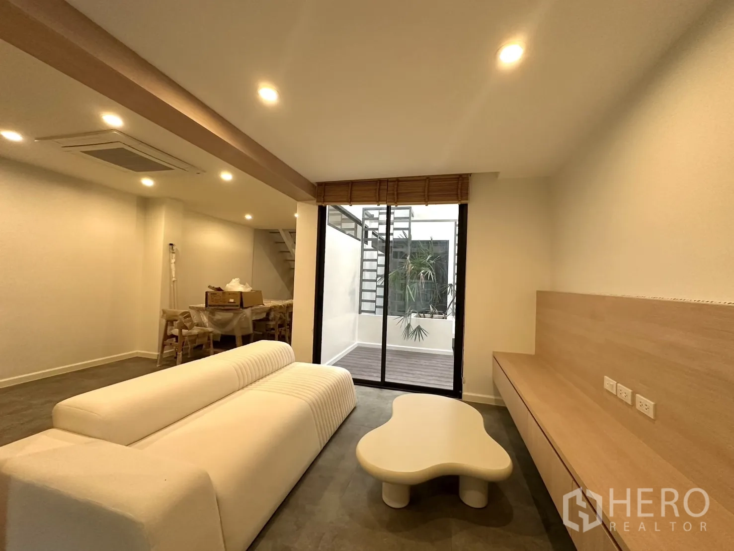 带办公室的家 出租在Phra Khanong, Bangkok - 客厅面向落地推拉门，连接带植物与楼梯的小天井。