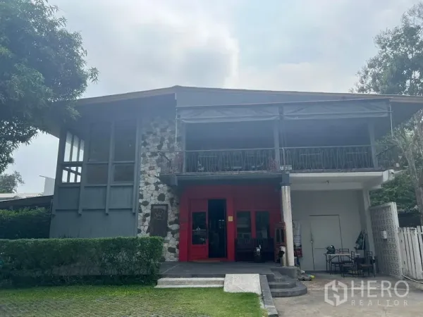 บ้าน ให้เช่าในKhlong Toei, Bangkok - ภาพระยะใกล้ของบ้าน ผนังหิน ระเบียงชั้นบนแบบมีหลังคา และทางเข้าโทนแดง