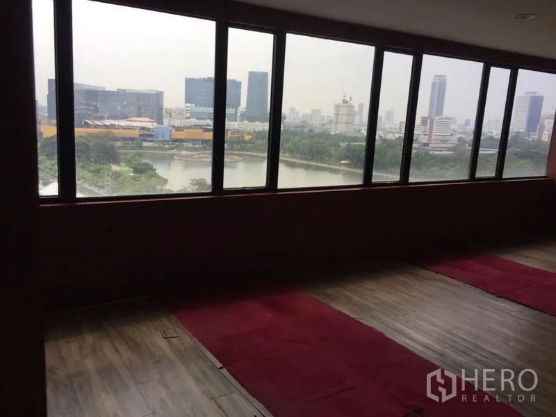 Office Space for sale in Watthana, Bangkok - Long office area with panoramic windows offering lake and skyline views over Sukhumvit.