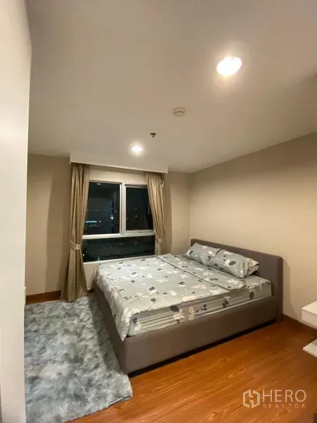 Condominium for rent - Cozy bedroom with double bed, wood flooring, rug, and window for natural light.