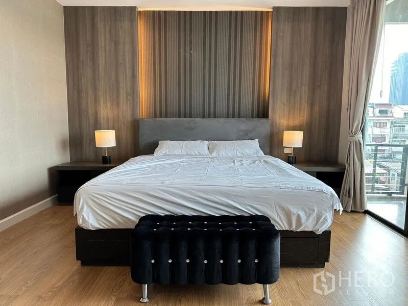 ทาวน์เฮาส์ ให้เช่าในKhlong Toei, Bangkok - เตียงคิงไซส์กับผนังหัวเตียงและโคมไฟหัวเตียง มองเห็นระเบียง