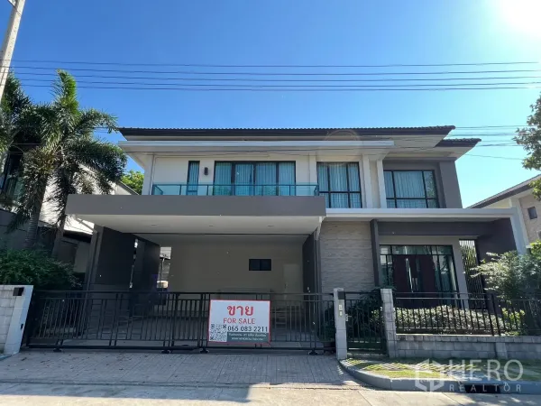 独立式住宅 出租或出售在Prawet, Bangkok - 现代两层独栋别墅外立面，带围栏车库和出售标牌。