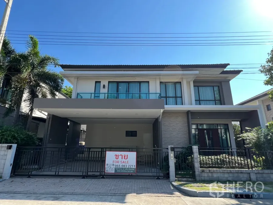 บ้าน ให้เช่าหรือขายในPrawet, Bangkok - ด้านหน้าบ้านเดี่ยวสองชั้นสไตล์โมเดิร์น พร้อมรั้วและโรงจอดรถ มีป้ายประกาศขาย