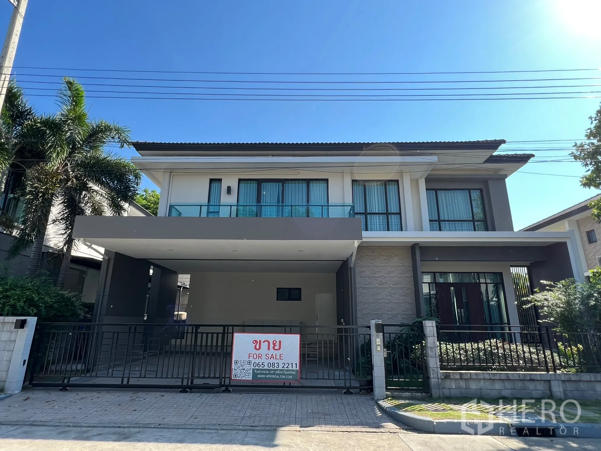 บ้าน ให้เช่าหรือขายในPrawet, Bangkok - ด้านหน้าบ้านเดี่ยวสองชั้นสไตล์โมเดิร์น พร้อมรั้วและโรงจอดรถ มีป้ายประกาศขาย