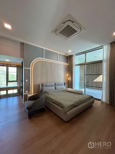 Detached House for rent in Saphan Sung, Bangkok - Primary bedroom with upholstered bed, LED headboard feature and floor-to-ceiling windows.