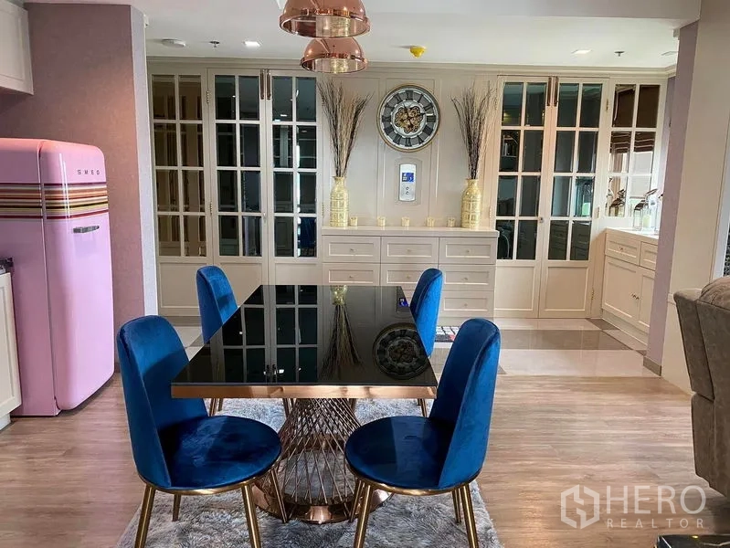 Condominium for sale in Bang Kho Laem, Bangkok - Elegant dining area with black glass table and blue velvet chairs.