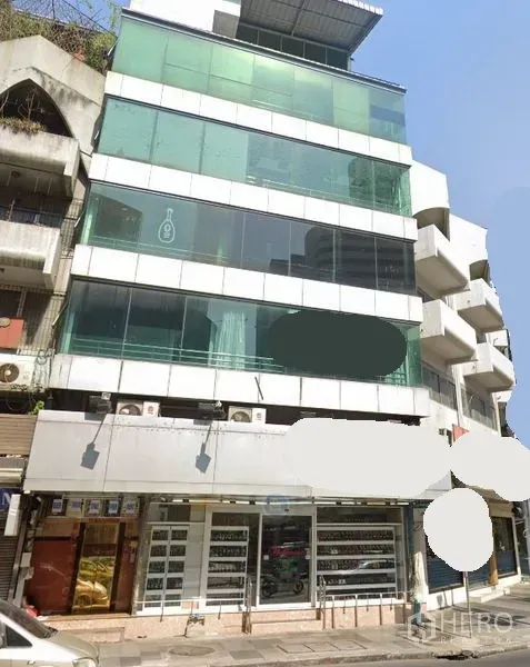 พื้นที่ขายปลีก ให้เช่าในWatthana, Bangkok - อาคารพาณิชย์สูงหลายชั้นพร้อมกระจกสีเขียวและหน้าร้านชั้นล่างกว้าง เห็นจากริมถนนในเขตวัฒนา กรุงเทพฯ