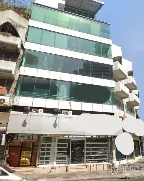 พื้นที่ขายปลีก ให้เช่าในWatthana, Bangkok - อาคารพาณิชย์สูงหลายชั้นพร้อมกระจกสีเขียวและหน้าร้านชั้นล่างกว้าง เห็นจากริมถนนในเขตวัฒนา กรุงเทพฯ