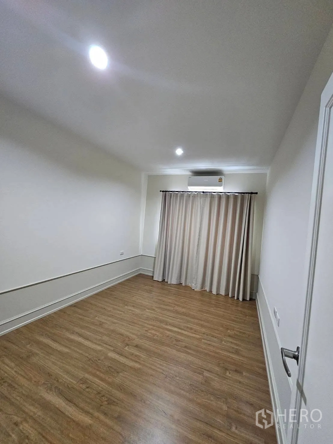 ทาวน์เฮาส์ for rent in Saphan Sung, Bangkok - ห้องนอนที่สามโล่ง พื้นไม้ หน้าต่างพร้อมผ้าม่าน และไฟดาวน์ไลท์