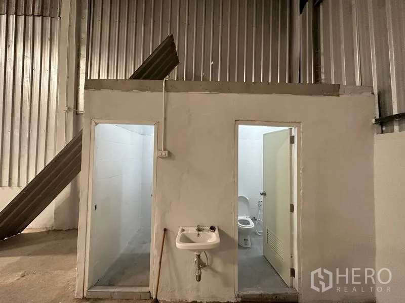 货栈 出租在Khlong Luang, Pathum Thani - 仓库内设卫生间区，含两个独立厕间与壁挂式洗手盆。