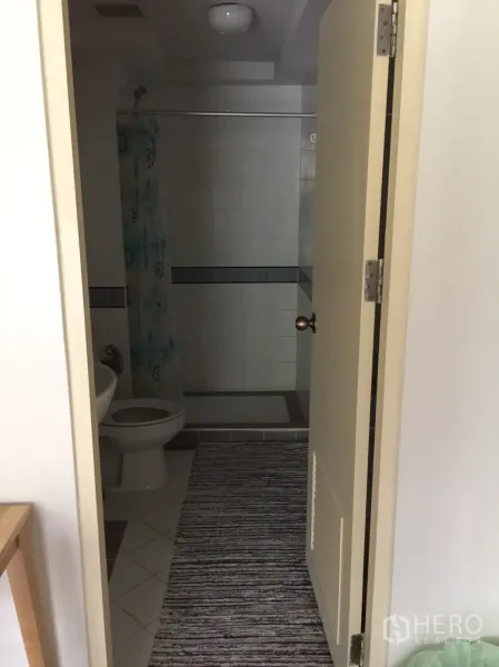 คอนโด ให้เช่าในKhlong Toei, Bangkok - ห้องน้ำมองจากประตู มีโถสุขภัณฑ์ อ่างล้างหน้า และพื้นที่อาบน้ำพร้อมม่าน