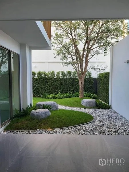 บ้าน ให้เช่าในSaphan Sung, Bangkok - ลานสวนส่วนตัว จัดภูมิทัศน์ด้วยต้นไม้ ทางหินโค้ง กรวด และแนวรั้วพุ่มไม้ ข้างชานพัก