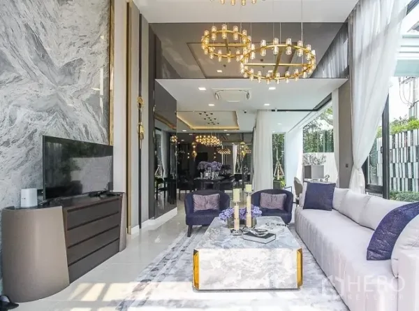 Detached House for rent or sale in Prawet, Bangkok - Luxury living room with marble feature wall and chandelier lighting.
