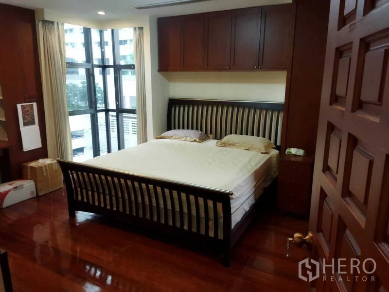 คอนโด ให้เช่าในPathum Wan, Bangkok - ห้องนอนเตียงใหญ่ ตู้บิลท์อินไม้ พื้นไม้ และหน้าต่างกระจกมุม