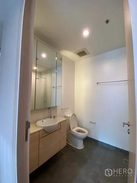 Condominium for rent or sale in Yan Nawa, Bangkok - Bathroom view from the doorway showing vanity unit, mirror cabinets and toilet.