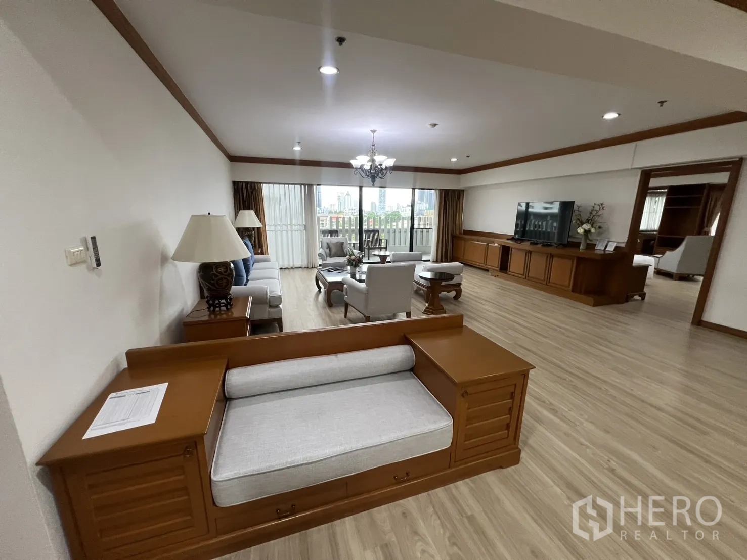 คอนโด ให้เช่าในKhlong Toei, Bangkok - ห้องนั่งเล่นขนาดใหญ่พร้อมโซฟา ชุดทีวี โคมระย้า และระเบียงเห็นวิวเมือง