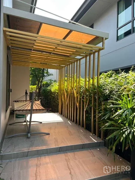 独立式住宅 出租在Bang Kapi, Bangkok - 覆盖式露台，现代凉棚，旁有绿化与吊床架。