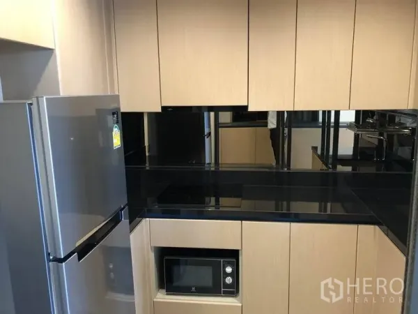 คอนโด ให้เช่าในWatthana, Bangkok - ครัวรูปตัวยูสไตล์โมเดิร์น ตู้ไม้สีอ่อน ท็อปหินสีดำ พร้อมเตา ไมโครเวฟ และตู้เย็น