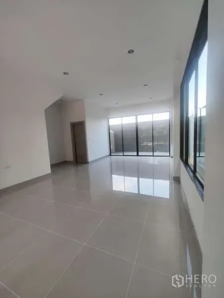 Home Office for rent in Bueng Kum, Bangkok - Bright upper floor with glossy tile flooring, recessed lights, and full-height sliding glass doors to a balcony.
