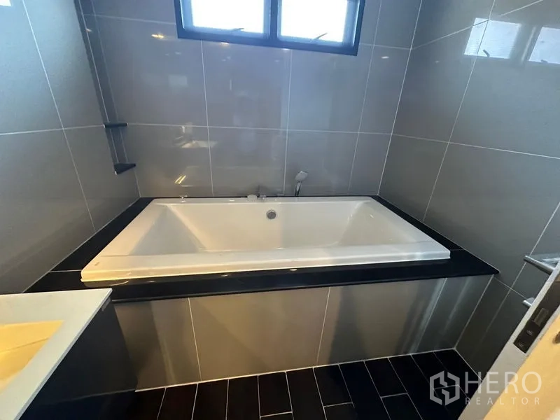 บ้าน ให้เช่าหรือขายในLam Luk Ka, Pathum Thani - ห้องน้ำมีอ่างอาบน้ำแบบลึก ตั้งอยู่ในห้องปูกระเบื้องพร้อมหน้าต่าง